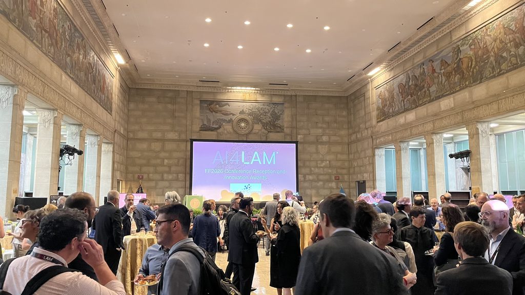 view of conference attendees in large marble room. Screen in back says AI4LAM.