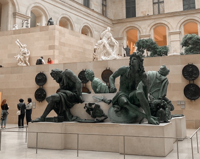 Visitors explore a vast museum sculpture hall displaying large bronze and marble figural works across multiple levels, illustrating the scale and depth of cultural collections that small and mid-sized institutions are working to bring into the digital age with the right support and tools. Photo credit: Cayla Long via Dupe Photos